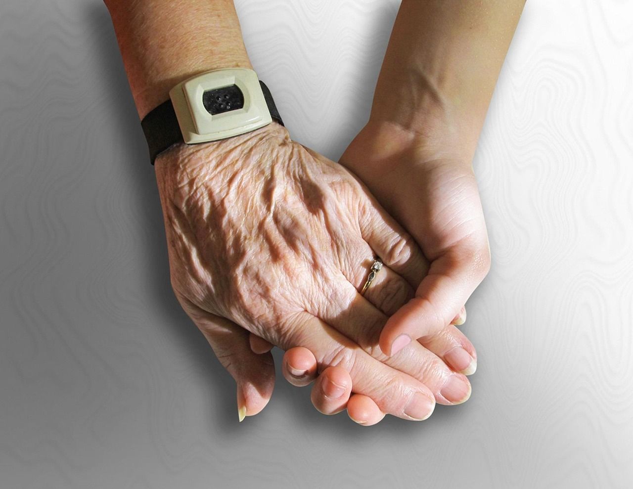 A younger hand holding an older hand