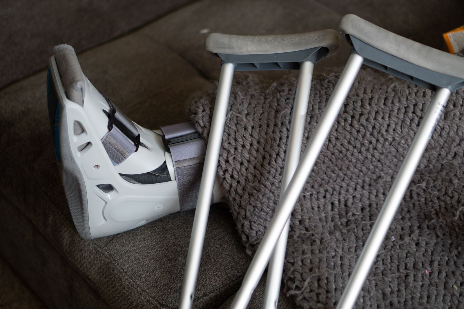 Crutches and an orthopedic boot beside a sofa