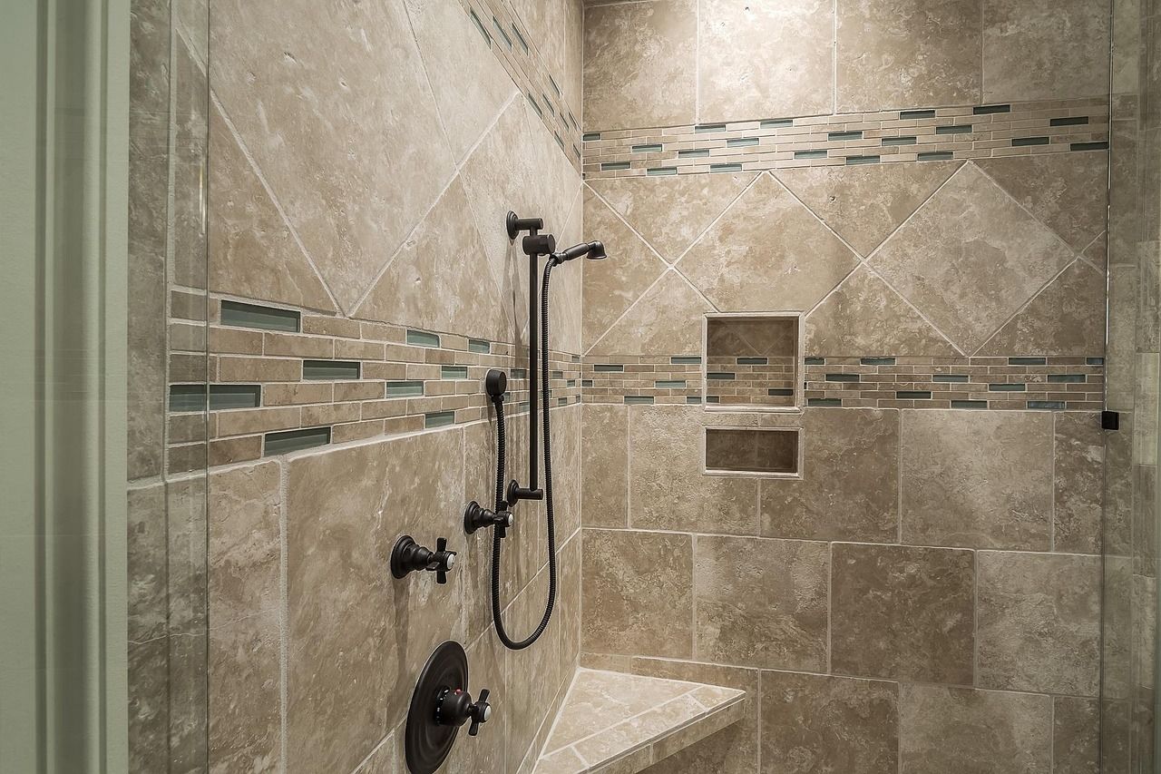 Shower with a handheld shower head on a slide bar and a built-in bench